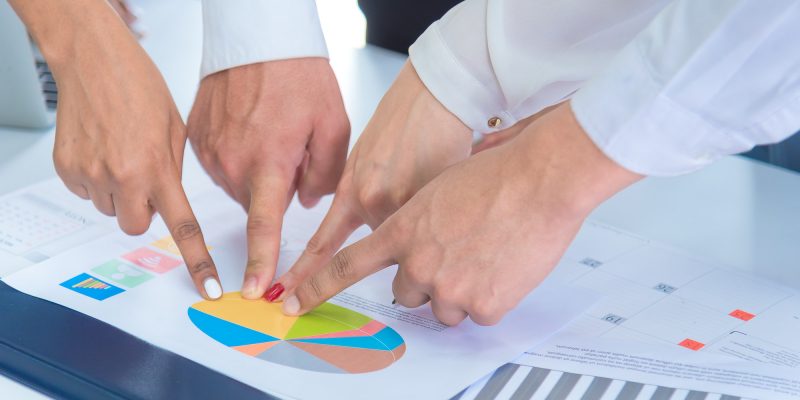 businees people pointing finger at sales target pie chart