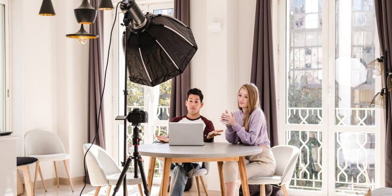 video bloggers making a video with a professional camera on a tripod at home.